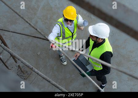 Blick von oben auf einer Baustelle diskutieren ein Ingenieur und Architekt auf einem Laptop. Stockfoto