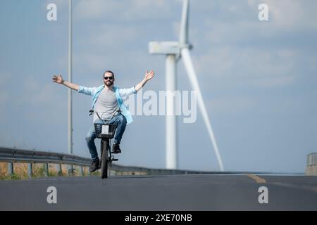 Rückansicht einer jungen Frau, die auf der Straße Fahrrad fährt Stockfoto