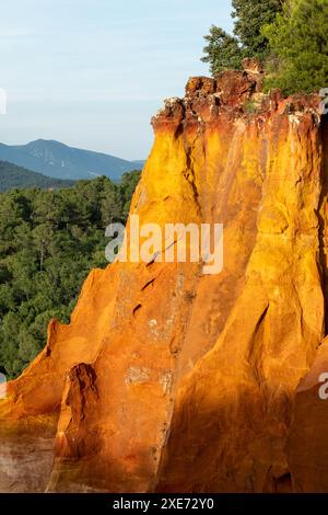 Blick auf ockerfarbene Klippen und die umliegende Landschaft, fotografiert von der historischen Stadt Roussillon, Provence im Süden Frankreichs. Stockfoto