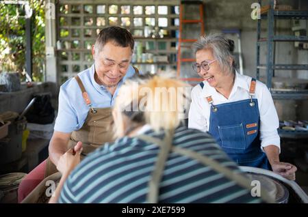 Porträt eines asiatischen Seniorenpaares, das gemeinsam in der Töpferwerkstatt aktiv wird. Stockfoto