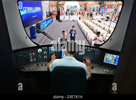 (240626) -- QINGDAO, 26. Juni 2024 (Xinhua) -- Ein Besucher wirft einen Blick in das Cockpit eines CETROVO 1,0 U-Bahn-Autos in Qingdao, ostchinesischer Provinz Shandong, 26. Juni 2024. Der U-Bahn-Wagen CETROVO 1,0 wurde am Mittwoch in Qingdao auf den Markt gebracht. Mit einer Karosserie und einem Rahmen aus Kohlefaser-Verbundwerkstoff ist er leichter und energieeffizienter als die herkömmliche U-Bahn. (Xinhua/Li Ziheng) Stockfoto