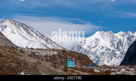 Hoch aufragende eisbedeckte Berge von Tserko Ri und Gangchempo, und wunderschöne türkisfarbene Berghütte im Dorf Langtang, Langtang Valley, Himalaya Stockfoto