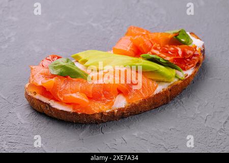 Hausgemachtes Toast-Sandwich mit Lachs, Avocado und Basilikum Stockfoto