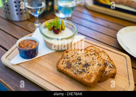 Entenleberpastete Vorspeise mit Obst und Nusskuchen in einem tschechischen Restaurant, serviert auf einem Holzbrett Stockfoto