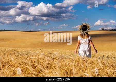 Frau in weißem Kleid steht auf dem Feld mit Weizen Stockfoto