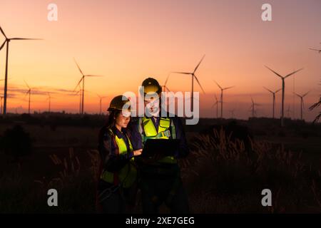 Ingenieure, die bei Sonnenuntergang an Windturbinen arbeiten, sind Windturbinen eine alternative Energiequelle. Stockfoto