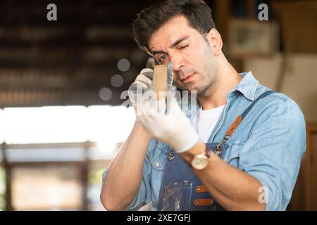 Der Zimmermann arbeitet in seiner Tischlerei. Das Sehvermögen wird verwendet, um die Genauigkeit zu gewährleisten. Stockfoto