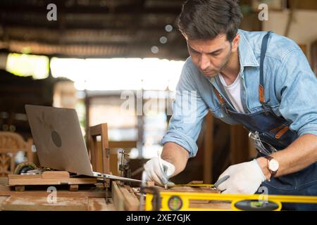 Der Zimmermann arbeitet in seiner Tischlerei. Das Sehvermögen wird verwendet, um die Genauigkeit zu gewährleisten. Stockfoto