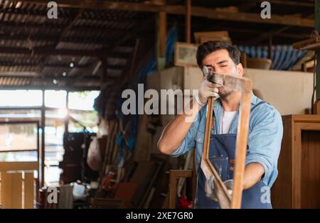 Der Zimmermann arbeitet in seiner Tischlerei. Das Sehvermögen wird verwendet, um die Genauigkeit zu gewährleisten. Stockfoto