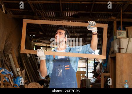 Der Zimmermann arbeitet in seiner Tischlerei. Das Sehvermögen wird verwendet, um die Genauigkeit zu gewährleisten. Stockfoto