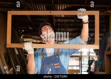 Der Zimmermann arbeitet in seiner Tischlerei. Das Sehvermögen wird verwendet, um die Genauigkeit zu gewährleisten. Stockfoto