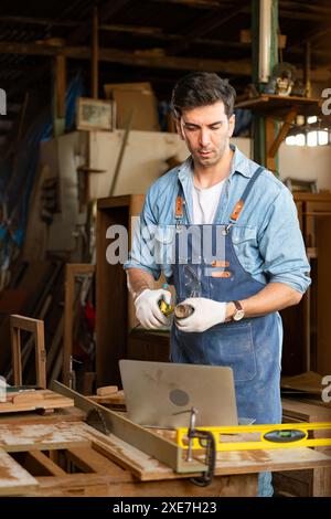 Der Zimmermann arbeitet in seiner Tischlerei. Das Sehvermögen wird verwendet, um die Genauigkeit zu gewährleisten. Stockfoto