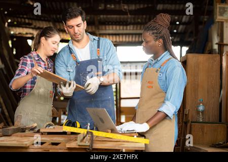 Zimmermann und seine Assistentin arbeiten zusammen in einer Tischlerei Stockfoto