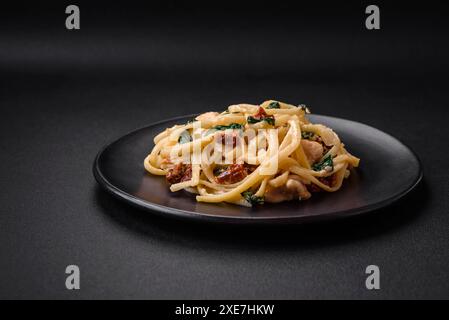 Leckere Pasta mit Spinat, sonnengetrockneten Tomaten, Käse, Zwiebeln Stockfoto