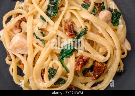 Leckere Pasta mit Spinat, sonnengetrockneten Tomaten, Käse, Zwiebeln Stockfoto