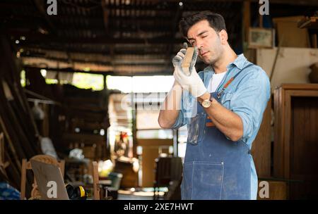 Der Zimmermann arbeitet in seiner Tischlerei. Das Sehvermögen wird verwendet, um die Genauigkeit zu gewährleisten. Stockfoto