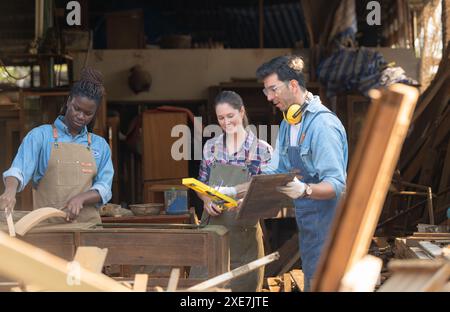 Zimmermann und seine Assistentin arbeiten zusammen in einer Tischlerei Stockfoto