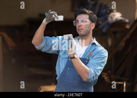 Der Zimmermann arbeitet in seiner Tischlerei. Das Sehvermögen wird verwendet, um die Genauigkeit zu gewährleisten. Stockfoto