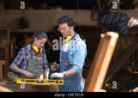 Zimmermann und seine Assistentin arbeiten zusammen in einer Tischlerei Stockfoto