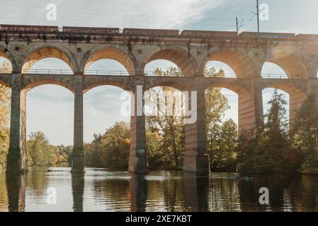 Eisenbahnbrücke mit Fluss in Bietigheim-Bissingen, Deutschland. Herbst. Eisenbahnviadukt über die Enz, erbaut 1853 von Karl vo Stockfoto