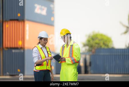 Porträt einer asiatischen Ingenieurin und Arbeiterin, die mit einer Mitarbeiterin auf dem Übersee-Containerbahnhof arbeitet. Stockfoto