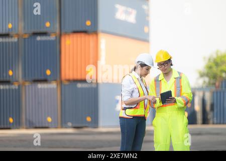 Porträt einer asiatischen Ingenieurin und Arbeiterin, die mit einer Mitarbeiterin auf dem Übersee-Containerbahnhof arbeitet. Stockfoto