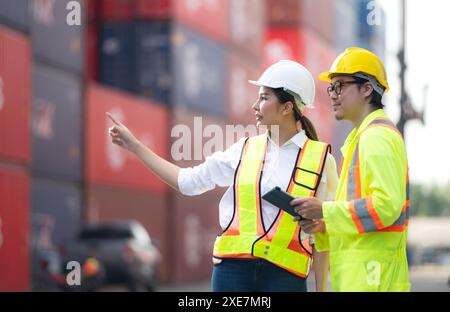 Porträt einer asiatischen Ingenieurin und Arbeiterin, die mit einer Mitarbeiterin auf dem Übersee-Containerbahnhof arbeitet. Stockfoto