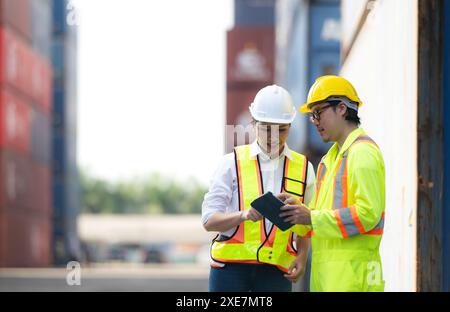 Porträt einer asiatischen Ingenieurin und Arbeiterin, die mit einer Mitarbeiterin auf dem Übersee-Containerbahnhof arbeitet. Stockfoto