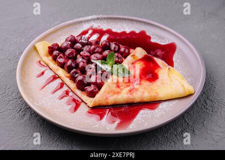 Pfannkuchen mit Kirschen auf dem Teller von oben Stockfoto