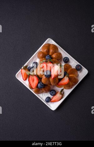 Köstliche Cupcakes oder Muffins mit Rosinen und Nüssen, Erdbeeren und Heidelbeeren Stockfoto