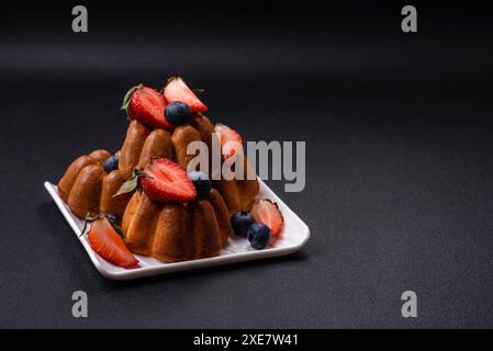 Köstliche Cupcakes oder Muffins mit Rosinen und Nüssen, Erdbeeren und Heidelbeeren Stockfoto