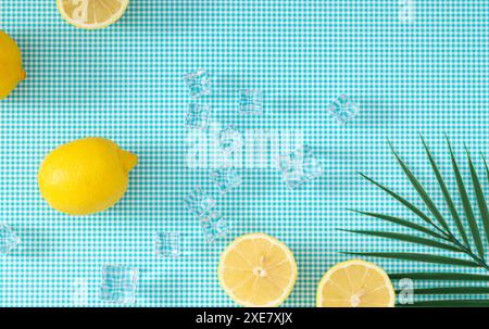 Kreatives Sommerlayout mit Zitronen, Eiswürfeln und tropischem grünem Palmenblatt auf weißem und blauem Hintergrund. Minimales Sommerfrucht-Konzept. Stockfoto
