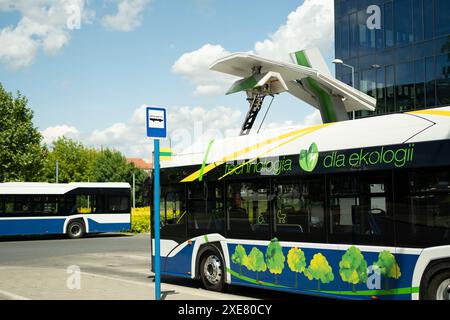 Ein Elektrobus parkt an einer leeren Bushaltestelle. Stockfoto