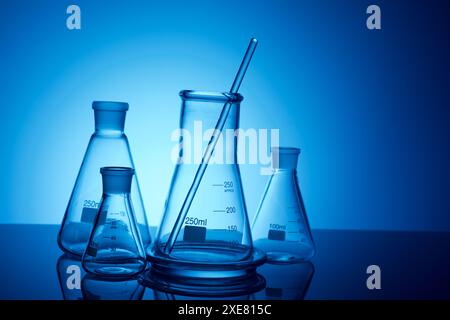 Nahaufnahme eines Glasbechers, der auf einer Laborarbeitsfläche steht und von hinten beleuchtet wird. Stockfoto