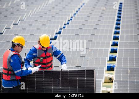 Photovoltaik-Ingenieure arbeiten an schwimmender Photovoltaik. Prüfen und reparieren Sie die auf dem Wasser schwimmenden Solarpaneele. Stockfoto