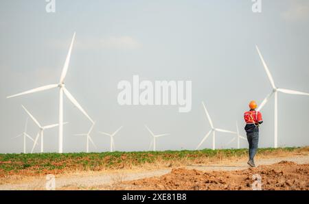 Ingenieur, der in einer Windkraftanlage arbeitet, mit blauem Himmel Hintergrund Stockfoto