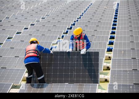 Photovoltaik-Ingenieure arbeiten an schwimmender Photovoltaik. Prüfen und reparieren Sie die auf dem Wasser schwimmenden Solarpaneele. Stockfoto