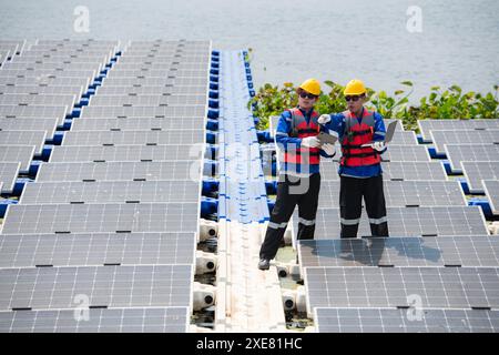 Photovoltaik-Ingenieure arbeiten an schwimmender Photovoltaik. Prüfen und reparieren Sie die auf dem Wasser schwimmenden Solarpaneele. Stockfoto