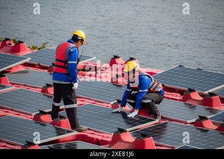 Photovoltaik-Ingenieure arbeiten an schwimmender Photovoltaik. Prüfen und reparieren Sie die auf dem Wasser schwimmenden Solarpaneele. Stockfoto