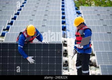 Photovoltaik-Ingenieure arbeiten an schwimmender Photovoltaik. Prüfen und reparieren Sie die auf dem Wasser schwimmenden Solarpaneele. Stockfoto