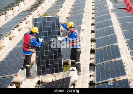 Photovoltaik-Ingenieure arbeiten an schwimmender Photovoltaik. Prüfen und reparieren Sie die auf dem Wasser schwimmenden Solarpaneele. Stockfoto