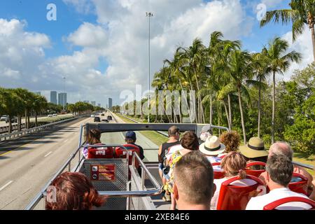 Miami, Florida, USA - 3. Dezember 2023: Menschen auf dem Oberdeck eines Doppeldeckerbus auf einer Autobahn in der Nähe des Zentrums von Miami Stockfoto