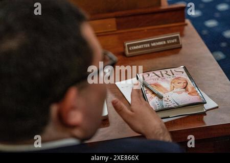 Washington, Usa. Juni 2024. "Paris, the Memoir"-Buch liegt auf einem Tisch neben einem Mitglied des Komitees, wie Paris Hilton, Lived-Experience Advocate und CEO, 11:11 Media, vor dem House Committee on Ways and Means während einer Anhörung mit dem Titel "Stärkung der Kinderfürsorge und Schutz der amerikanischen Kinder" auf dem Capitol Hill in Washington aussagt. DC am Mittwoch, 26. Juni 2024. Foto: Ken Cedeno/UPI Credit: UPI/Alamy Live News Stockfoto