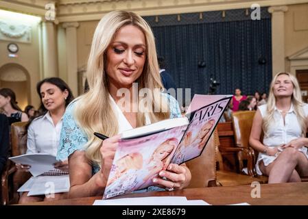 Washington, Usa. Juni 2024. Paris Hilton, Living-Experience Advocate und CEO, 11:11 Media, unterschreibt ihr Buch „Paris the Memoir“ während einer Pause von der Aussage vor dem House Committee on Ways and Means während einer Anhörung mit dem Titel „Stärkung der Kinderfürsorge und Schutz Amerikas Kinder“ auf dem Capitol Hill in Washington, DC am Mittwoch, 26. Juni 2024. Foto: Ken Cedeno/UPI Credit: UPI/Alamy Live News Stockfoto