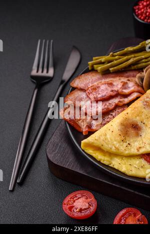 Köstliches frisches Omelett mit Kirschtomaten, Speck, Spargel und Gewürzen Stockfoto