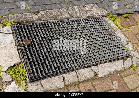 Metallsturm-Drainagegitter auf einem gepflasterten Bürgersteig. Nahaufnahme. Stockfoto