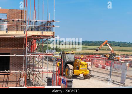 Baustellenfahrzeuge auf einer neuen Wohnsiedlung, Großbritannien. Stockfoto