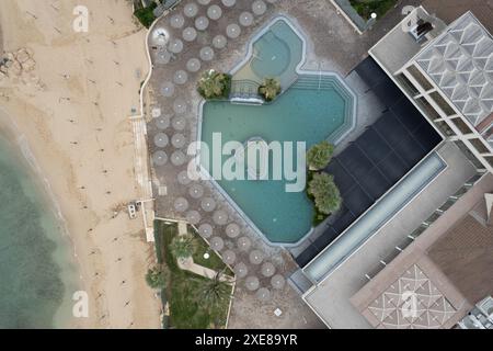 Drohnenantenne eines leeren verlassenen Schwimmbades. Schmutziges Wasser verlassenes Hotel. Stockfoto