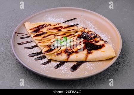 Crepes mit frischen Bananensträhnen und dunkler Schokolade Stockfoto