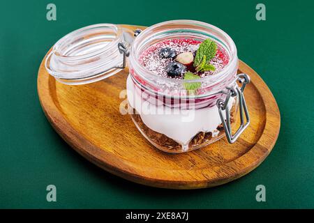 Müsli mit Nüssen, Joghurt und Beeren in einem Glas Stockfoto